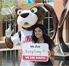 SouthPaw and a °ϲʿ¼ Student hold a sign that states: We Are Accepting
